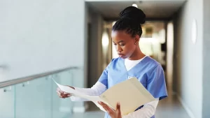 Medical records, black woman and nurse in hospital with reading for diagnosis of patient.