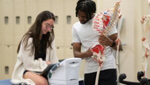 Instructor and student studying an anatomy model