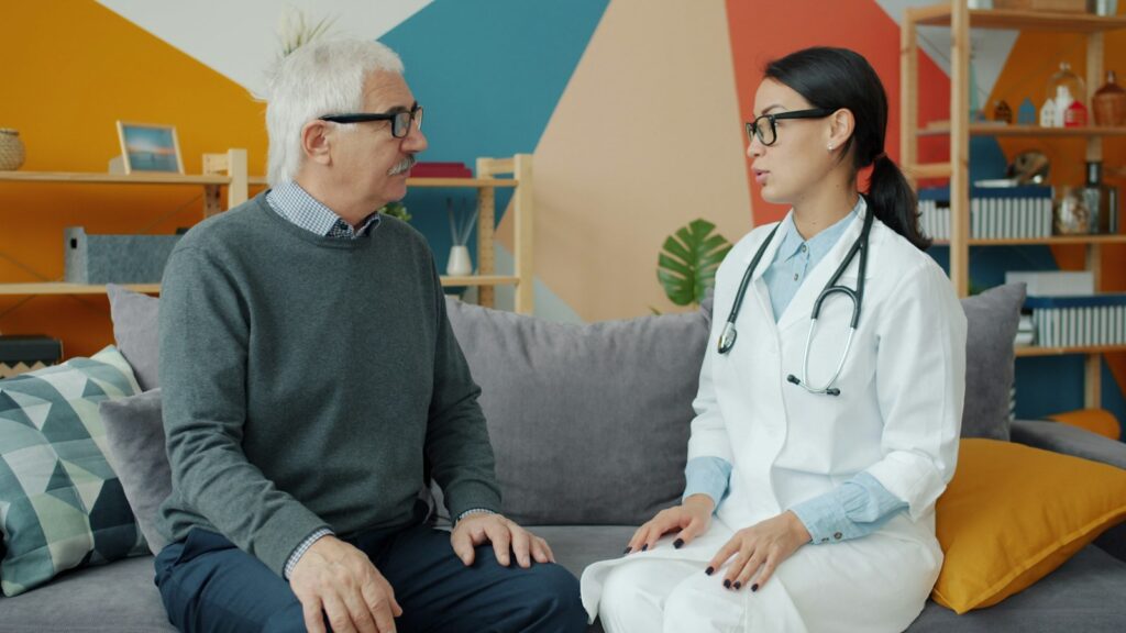 Doctor talking with an elderly patient at home