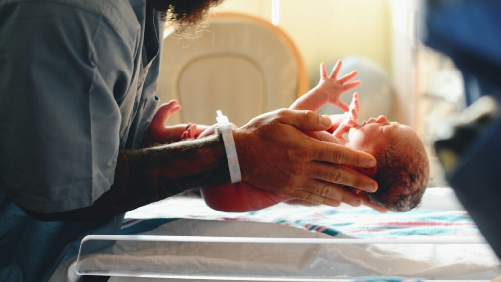 Clinician placing a newborn on a scale