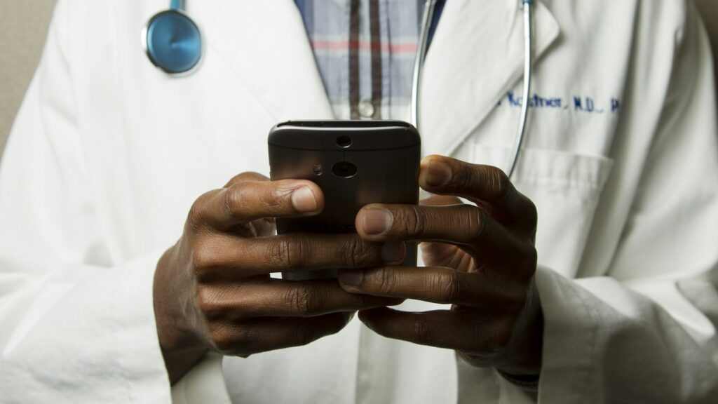 Clinician with a stethoscope using a phone
