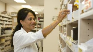 Pharmacist reaching for medication on a shelf