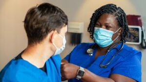 Two clinicians in blue scrubs