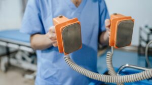 Clinician in scrubs holding equipment